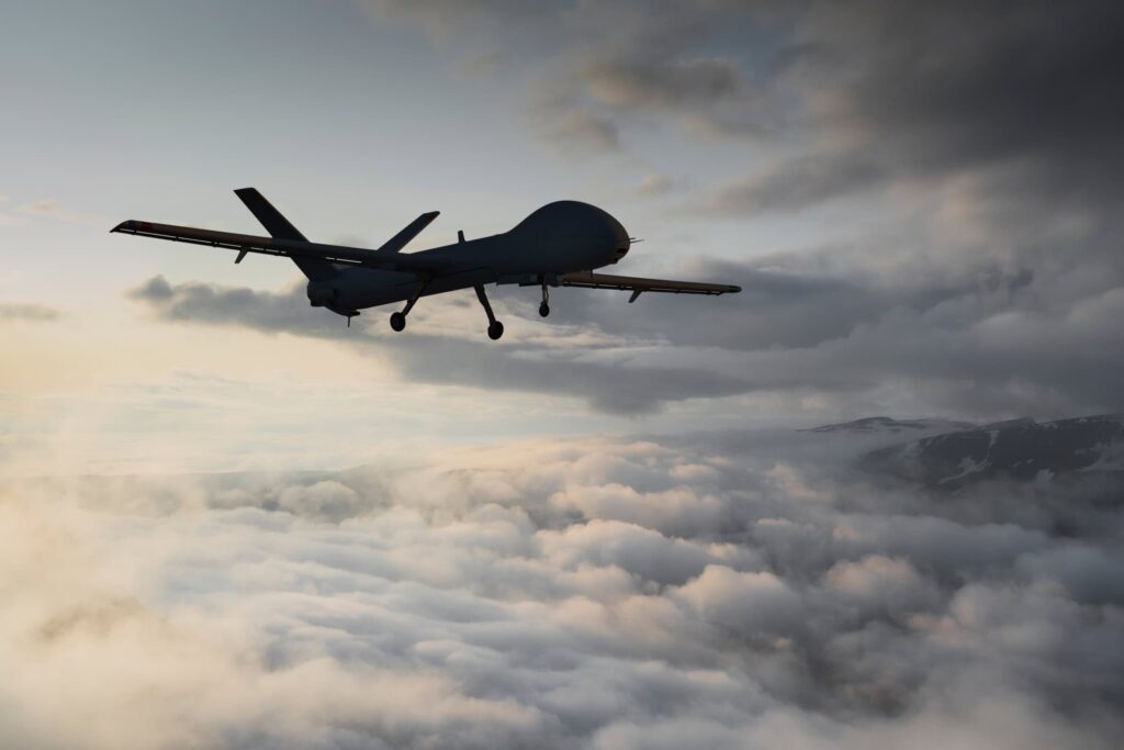 A long-winged aircraft above clouds at dusk.