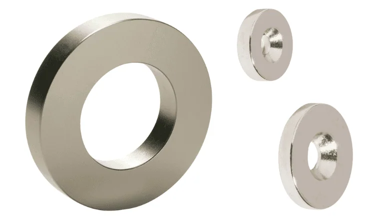 Nickel-plated neodymium ring magnets in three different sizes on a white background.